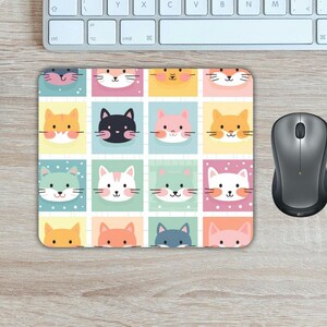 May include: A colorful mouse pad with a repeating pattern of cute cartoon cats in various colors and poses. The background is a grid of pastel colors.