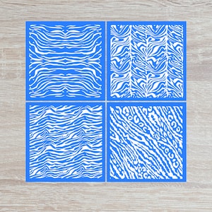 May include: Four blue square stencils with white zebra print designs. The stencils are arranged in a 2x2 grid.