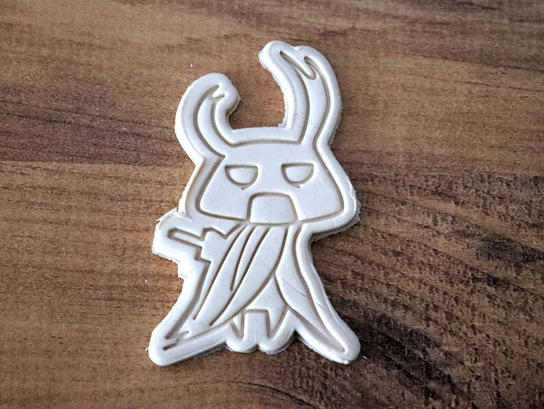 May include: A white ceramic mug with a black handle and the text "But First, Coffee" in a bold, black font. The mug is set against a blurred background, suggesting a cozy setting. The mug appears to be approximately 4 inches tall.