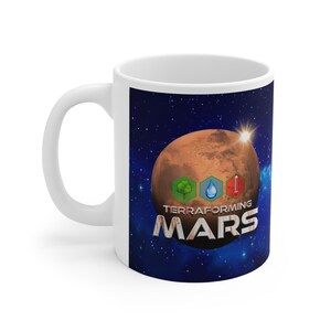 May include: White ceramic mug featuring a design of Mars with the words "TERRAFORMING MARS" in a textured font. The design includes icons of a tree, water droplet, and thermometer. The background is a starry night sky.