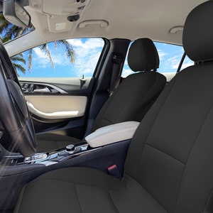 May include: Black car seat covers installed in a car interior. The covers are made of a durable, water-resistant material and are designed to protect the original seats from wear and tear.