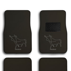 May include: Set of four black car floor mats with a white outline of the Taurus constellation and the word "TAURUS" printed on each mat.