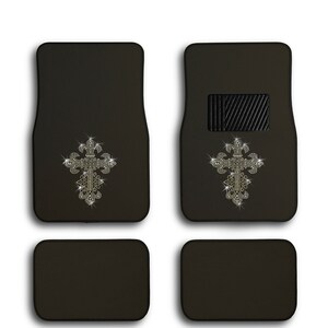 May include: Set of four black car floor mats with a rhinestone cross design. The front mats have a driver's side heel pad.