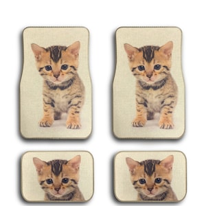 May include: Set of four beige car floor mats with a cute brown tabby kitten image on each mat.