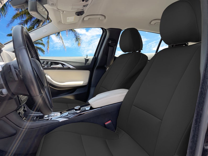 May include: Black car seat covers installed in a car interior. The covers are made of a durable, water-resistant material and are designed to protect the original seats from wear and tear.