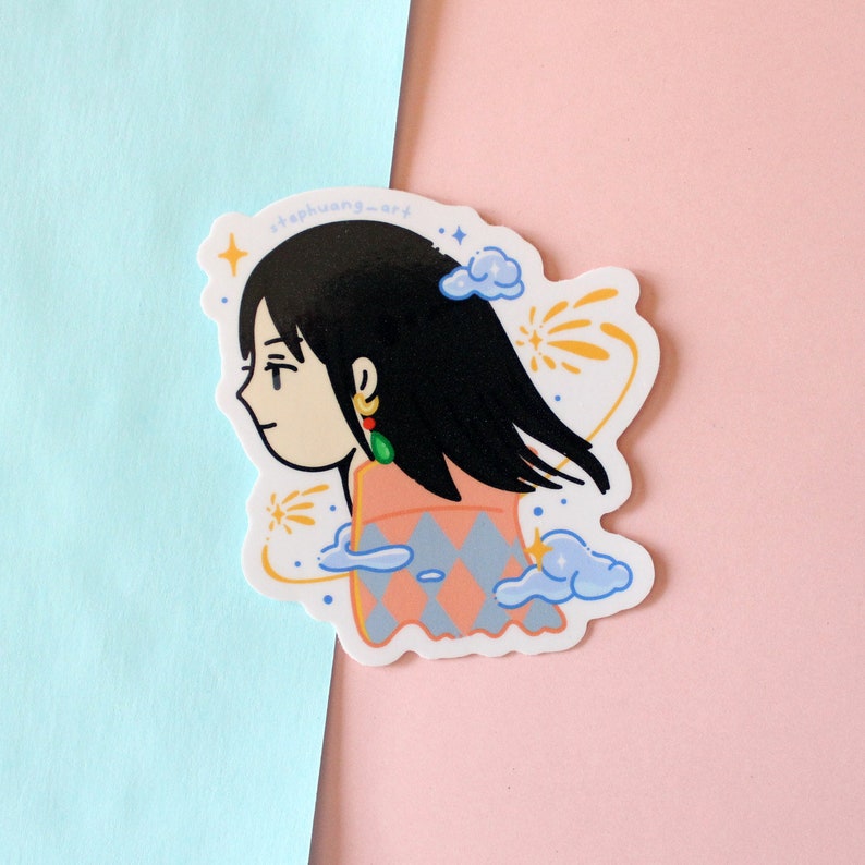 Może przedstawiać: Wycięta naklejka z kresk&oacute;wkową ilustracją osoby z czarnymi włosami, ubranej w brzoskwiniowo-niebieską bluzkę we wzory i zielone kolczyki. Naklejka ma białą obw&oacute;dkę i zawiera tekst "stephuang-art".