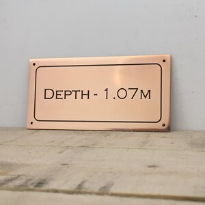 Bronze pool depth plaque.
