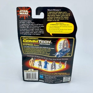 May include: A Star Wars Episode I action figure of Mace Windu, a Jedi Master, holding a blue lightsaber. The packaging features a black background with a silver and blue Commtech Reader, and the text "May the Force be with you".