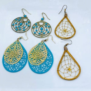 Könnte beinhalten: Set aus vier goldenen und türkisfarbenen Ohrringen. Zwei Paare zeigen ein türkisfarbenes Tropfenmuster mit goldenen Filigranen. Die anderen beiden Paare zeigen ein goldenes Filigranmuster auf türkisfarbenem Hintergrund.