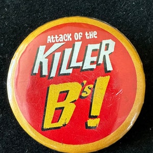 May include: A red and yellow button with the text "Attack of the Killer B's!" in white.