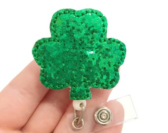 May include: Green glitter shamrock shaped badge holder with a clear plastic badge holder attached.
