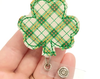 May include: Green and gold plaid shamrock shaped badge holder with a clear plastic retractable badge reel.