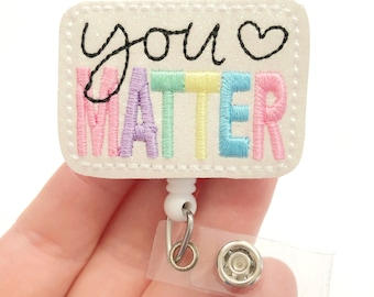 May include: White badge reel with a white rectangular patch that says "you ♥ matter" in rainbow colored embroidery.