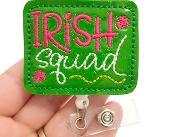 May include: Green glitter badge holder with white stitching and the text "Irish squad" in pink and white lettering. The badge holder has a clear plastic clip and a metal pin.