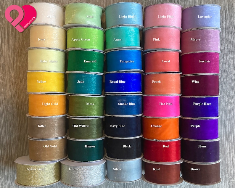 May include: A collection of 30 spools of sheer ribbon in various colors, including mint, light blue, light pink, lavender, ivory, apple green, aqua, pink, mauve, baby blue, emerald, turquoise, coral, fuchsia, yellow, jade, royal blue, peach, wine, light gold, moss, smoke blue, hot pink, purple haze, toffee, old willow, navy blue, orange, purple, old gold, hunter, black, red, plum, glitter gold, glitter silver, silver, rust, and brown.