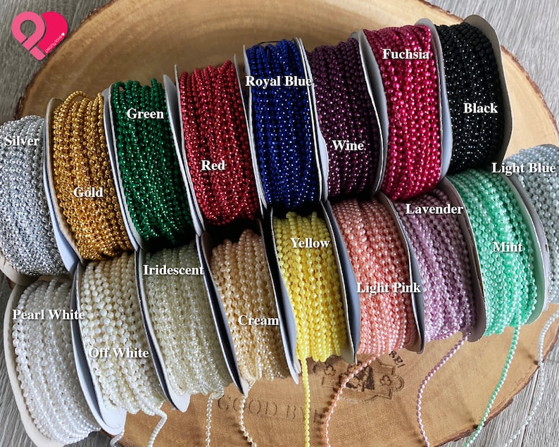 K&ouml;nnte beinhalten: Eine Auswahl an farbigen Perlenketten, darunter Silber, Gold, Gr&uuml;n, Rot, K&ouml;nigsblau, Wein, Fuchsia, Schwarz, Hellblau, Lavendel, Gelb, Irisierend, Mint, Hellrosa, Perlwei&szlig;, Creme und Offwhite.