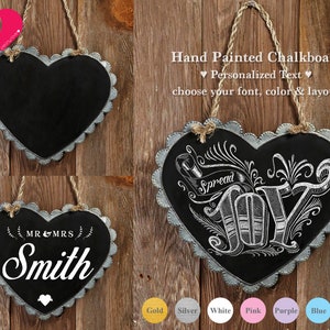 Puede incluir: Dos letreros de pizarra en forma de corazón con bordes festoneados. El letrero superior es negro con texto blanco que dice "Spread Joy". El letrero inferior es gris con texto blanco que dice "MR & MRS Smith".