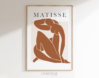 Puede incluir: Una impresión de arte minimalista con una figura desnuda estilizada en color terracota, con la palabra "MATISSE" en texto negro en la parte superior y "UMAJIANA STUDIO" en texto negro en la parte inferior.
