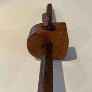 May include: A wooden tool with a long handle and a curved, adjustable head. The tool is used for copying shapes and profiles.