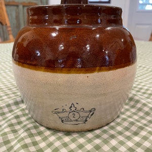 Early and decorative Robinson Ransbottom pottery two tone bean crock with one handle and the original lid.
