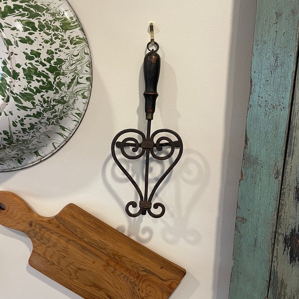 Antique footed cast iron trivet with a wooden handle circa 1800.