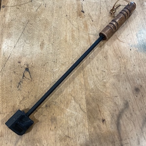 A vintage barbeque branding iron with three letters. R..rare   M..medium and W ..well done .