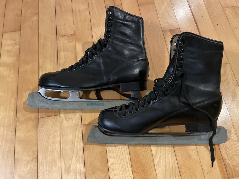 Vintage men's black leather figure skates with blade guards in