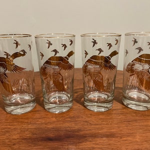 Four beautiful mid century water glasses with a duck design and gold trim on heavy bases.