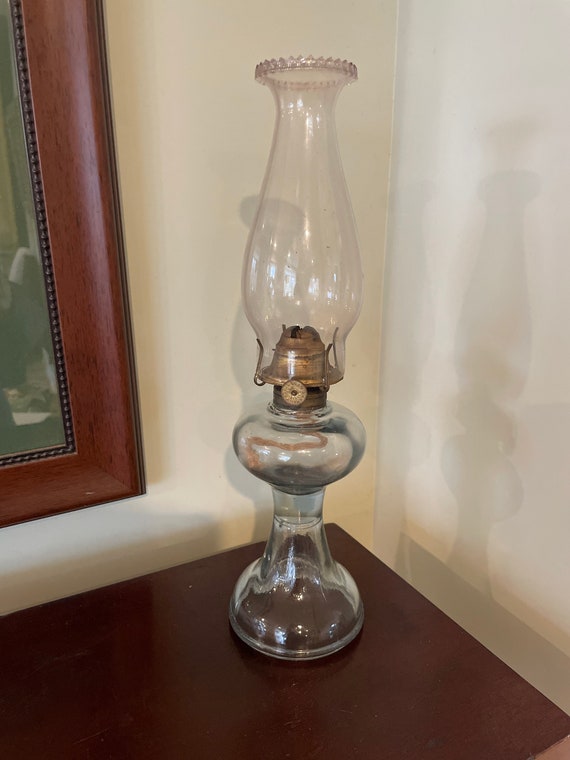 An antique glass base oil lamp in good "as found" condition complete with wick and chimney..