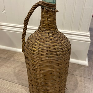 antique hand blown bottle encased in a pristine wicker envelope.