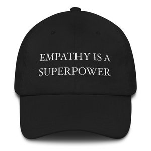 May include: Black baseball cap with white embroidered text that reads "Empathy is a superpower".
