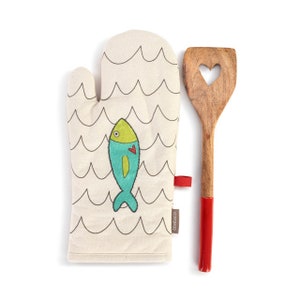 May include: A white oven mitt with a black and white wave pattern and a blue fish with a red heart. The mitt has a red tag with the word "Flamingo" on it. A wooden spatula with a red handle and a heart-shaped cutout is next to the mitt.