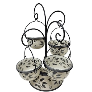 May include: A black metal stand with five hanging bowls. The bowls are white with a black and gray floral pattern.
