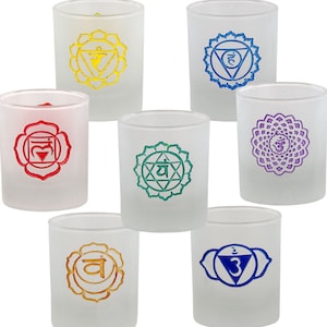 May include: Set of seven frosted glass candle holders with colorful chakra symbols. Each holder features a different chakra symbol and color, including red, orange, yellow, green, blue, indigo, and violet.