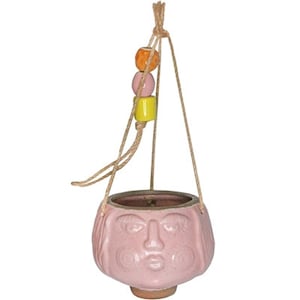 May include: Pink ceramic hanging planter shaped like a face with a rope hanger and colorful beads.