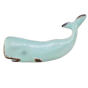 May include: A light blue whale figurine with a distressed finish. The whale is made of metal and has a realistic shape.