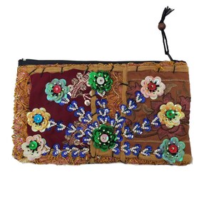 May include: A small, brown patchwork pouch with a zipper closure. The pouch is decorated with colorful sequins and beads in a floral pattern.