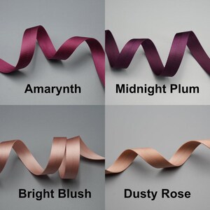 Peut inclure: Quatre rubans de diff&eacute;rentes nuances de violet et de rose sont pr&eacute;sent&eacute;s sur un fond gris. Les couleurs sont &eacute;tiquet&eacute;es "Amarynth", "Midnight Plum", "Bright Blush" et "Dusty Rose". Les rubans sont dispos&eacute;s en motifs courbes et fluides.