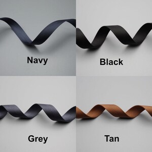 Peut inclure: Quatre &eacute;chantillons de ruban de couleurs marine, noir, gris et beige. Chaque ruban est ondul&eacute; et &eacute;tiquet&eacute; avec son nom de couleur. Le fond est gris uni.
