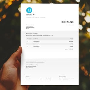 May include: A white document with the word "RECHNUNG" at the top right. The document has a blue logo and the text "MYBRAND" at the top left. The document is held by a hand against a blurred background of green and yellow.