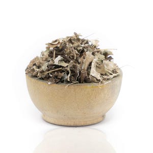 Peut inclure: Un bol en bois rempli d'herbes séchées, de couleur brun clair avec quelques morceaux blancs et gris.