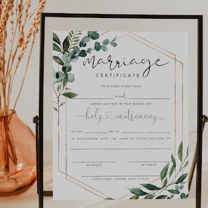Peut inclure: Un certificat de mariage encadré avec le mot "Marriage" en haut. Le certificat a un design géométrique doré et est décoré de feuilles vertes. Le certificat est dans un cadre noir.