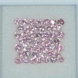 May include: A collection of round, light pink gemstones arranged in a square formation. Each gem has multiple facets, reflecting light. The gems are set against a white background, creating a clean and elegant presentation.