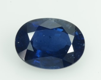 May include: A deep blue, oval-cut sapphire gemstone. The facets of the gem reflect light, creating a sparkling effect. The gemstone is set against a plain white background.