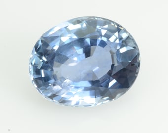 Könnte beinhalten: Ovale, hellblauer Edelstein mit facettierter Oberfläche. Der Edelstein hat einen hellblauen Farbton und reflektiert das Licht, wodurch ein funkelnder Effekt entsteht. Der Edelstein ist vor einem weißen Hintergrund platziert.