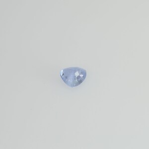 May include: A light blue, heart-shaped gemstone with a faceted surface. The gem is set against a plain white background, highlighting its color and shape. The facets catch the light, creating a sparkling effect.