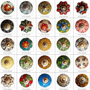 Peut inclure: Une collection de 25 boutons de meubles d&eacute;coratifs en c&eacute;ramique, aux couleurs et motifs floraux vari&eacute;s. Chaque bouton pr&eacute;sente un motif unique, notamment rouge, bleu, jaune et vert, avec une quincaillerie en m&eacute;tal dor&eacute;. Chaque bouton est num&eacute;rot&eacute;.