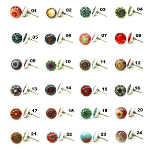 May include: A selection of 24 decorative cabinet knobs, each with a distinct, colourful pattern. The knobs showcase floral, geometric, and abstract designs, with a silver-tone metal base. The knobs are numbered 01 to 24.