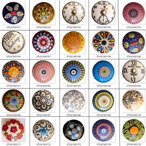 Peut inclure: Une collection de boutons de meubles d&eacute;coratifs avec divers motifs. Les styles incluent des motifs floraux, g&eacute;om&eacute;triques, des cadrans d'horloge et des motifs abstraits. Chaque bouton est rond et pr&eacute;sente une palette de couleurs et un design uniques.