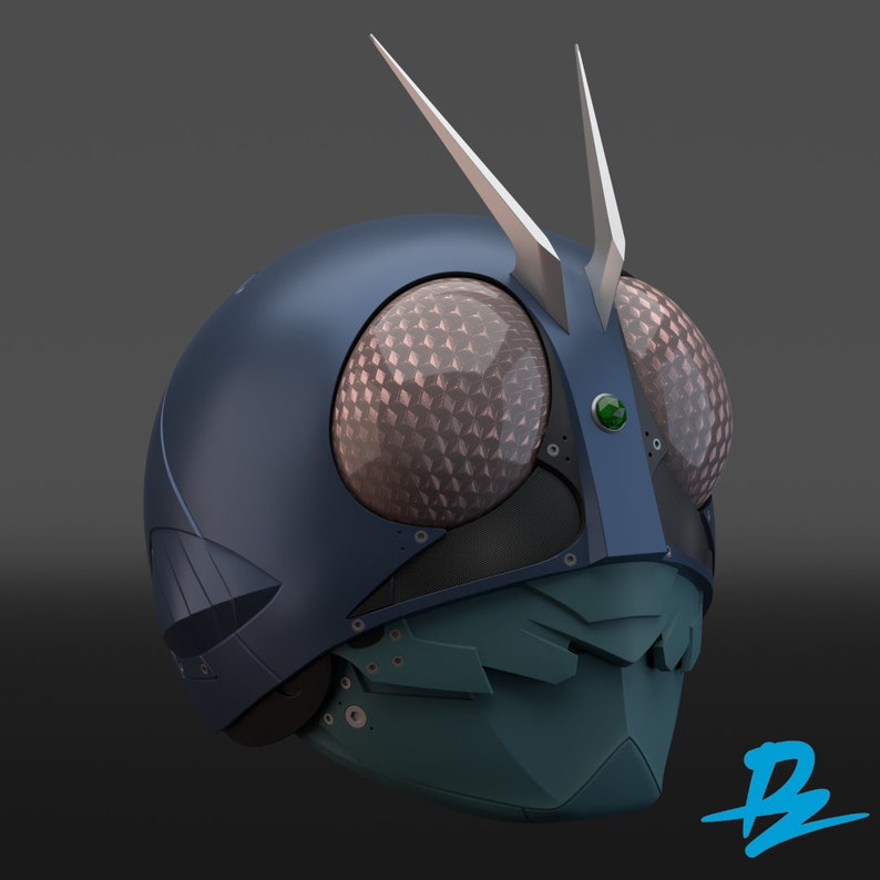 May include: A blue and green helmet with a silver antenna and a green gem in the center. The helmet has a textured surface and a geometric design.